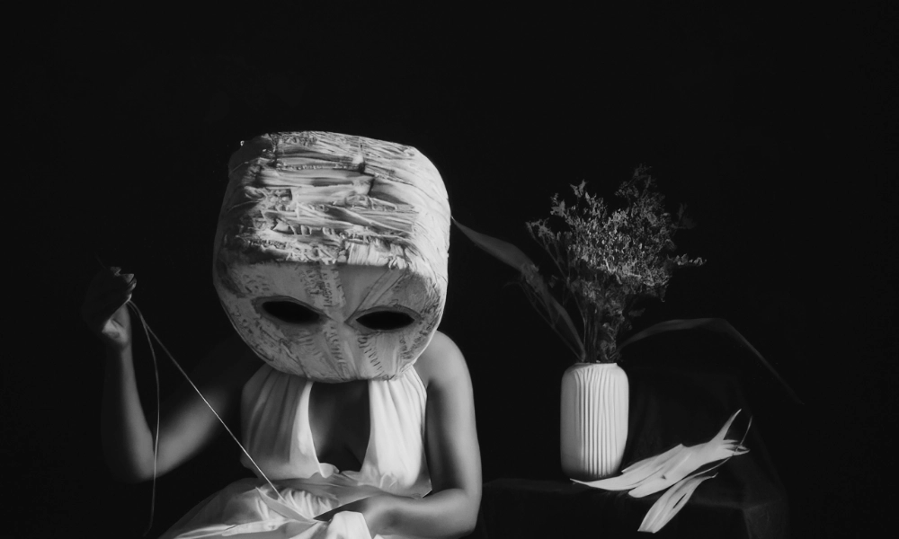 Darstellung einer Schauspielerin mit einer Maske auf dem Kopf. Sinnbildlich für die Schauspieltechnik von Jacques Lecoq